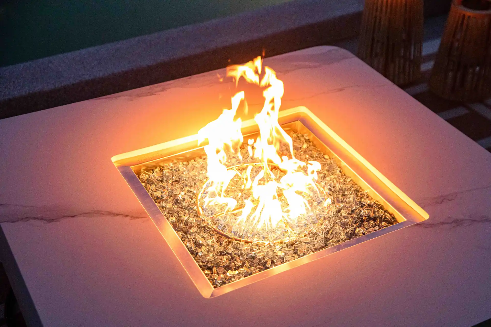 Close-up of glowing glass crystals in a marble fire pit