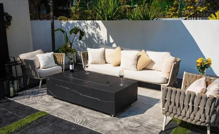 Round white fire pit at night with drinks